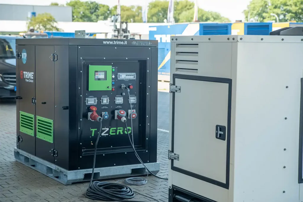 Großer Industrieller Batteriespeicher Panel Nahaufnahme des Batteriestands mit einem Thiet Stromerzeuger im Hintergrund2